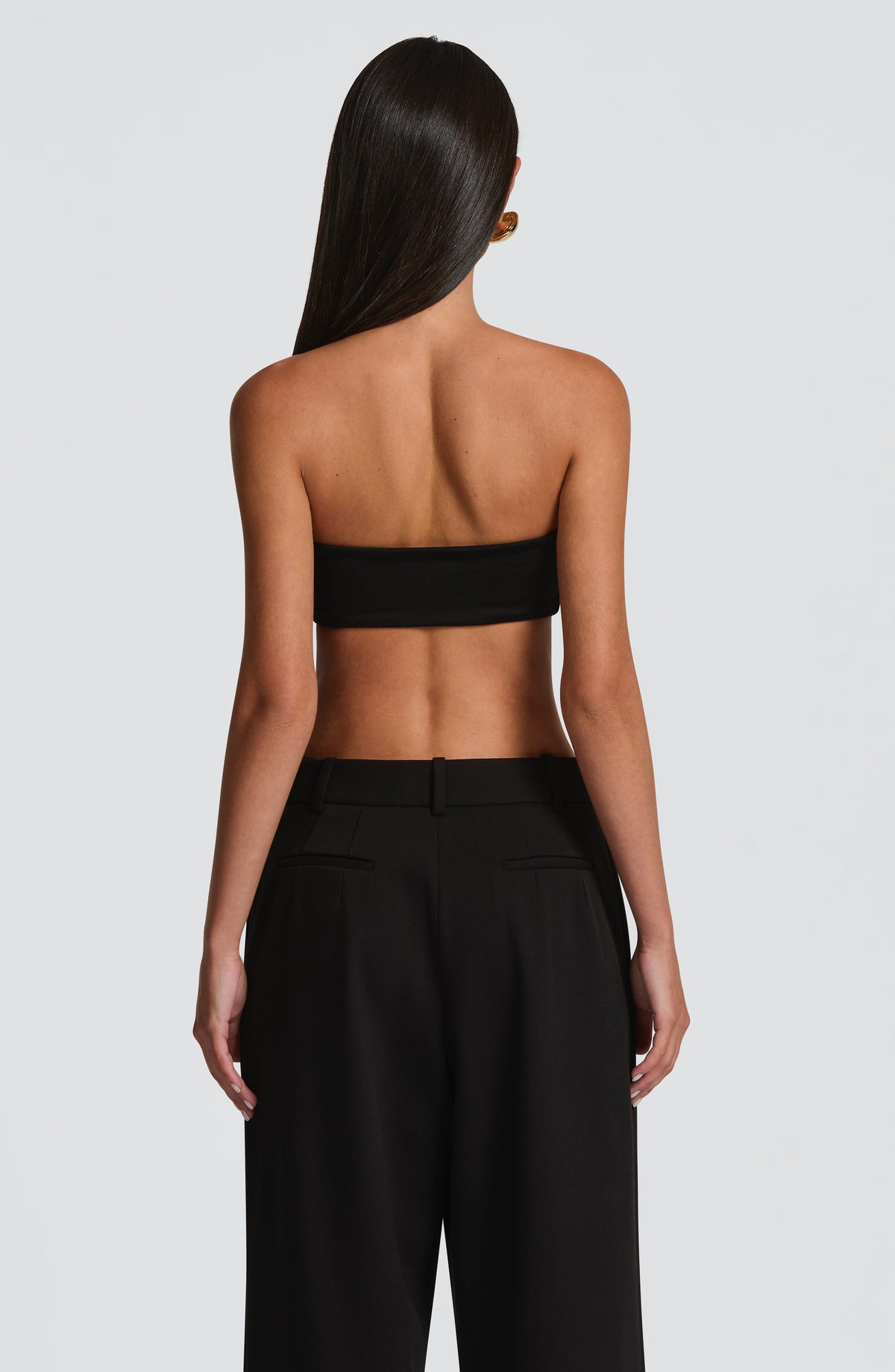 Top bandeau negro sin tirantes visto por la espalda.