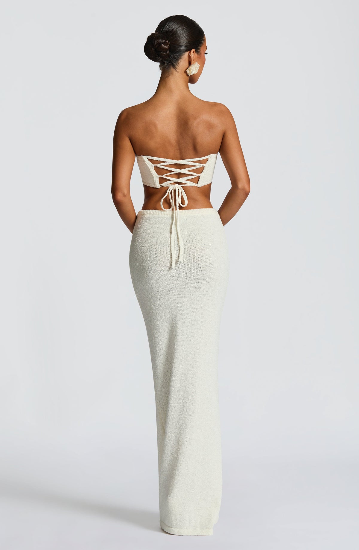 Top bandeau marfil con tiras cruzadas en la espalda y flor frontal