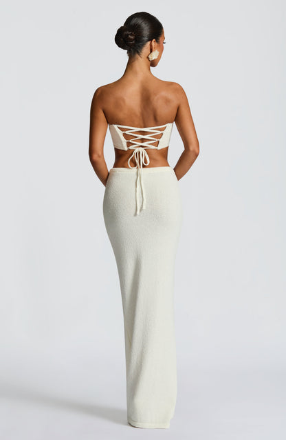 Top bandeau marfil con tiras cruzadas en la espalda y flor frontal