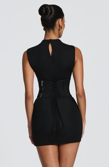 Vestido negro sin mangas con espalda abierta y detalle de cordón en la cintura
