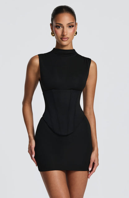 Vestido negro entallado sin mangas, cuello alto y paneles tipo corsé en la cintura