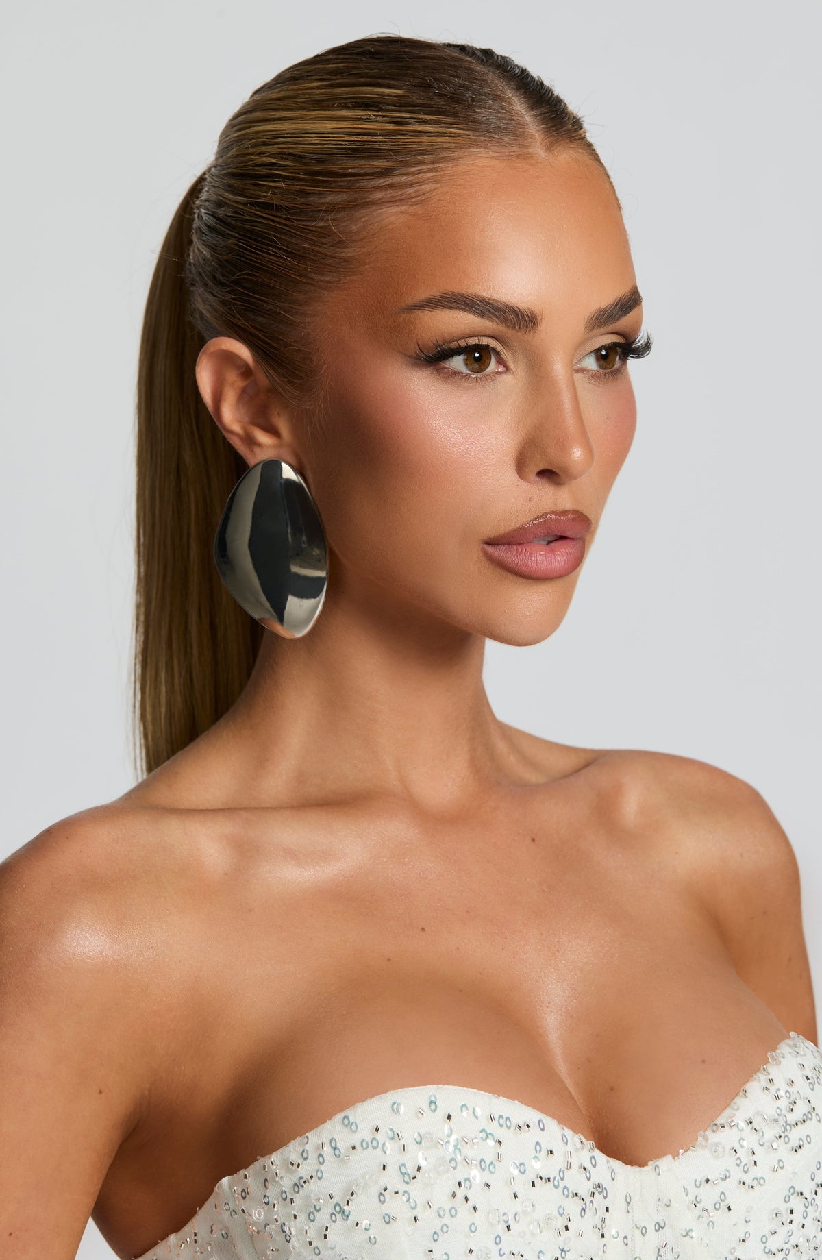Pendientes Yuki de plata, chapa ovalada pulida, junto al rostro